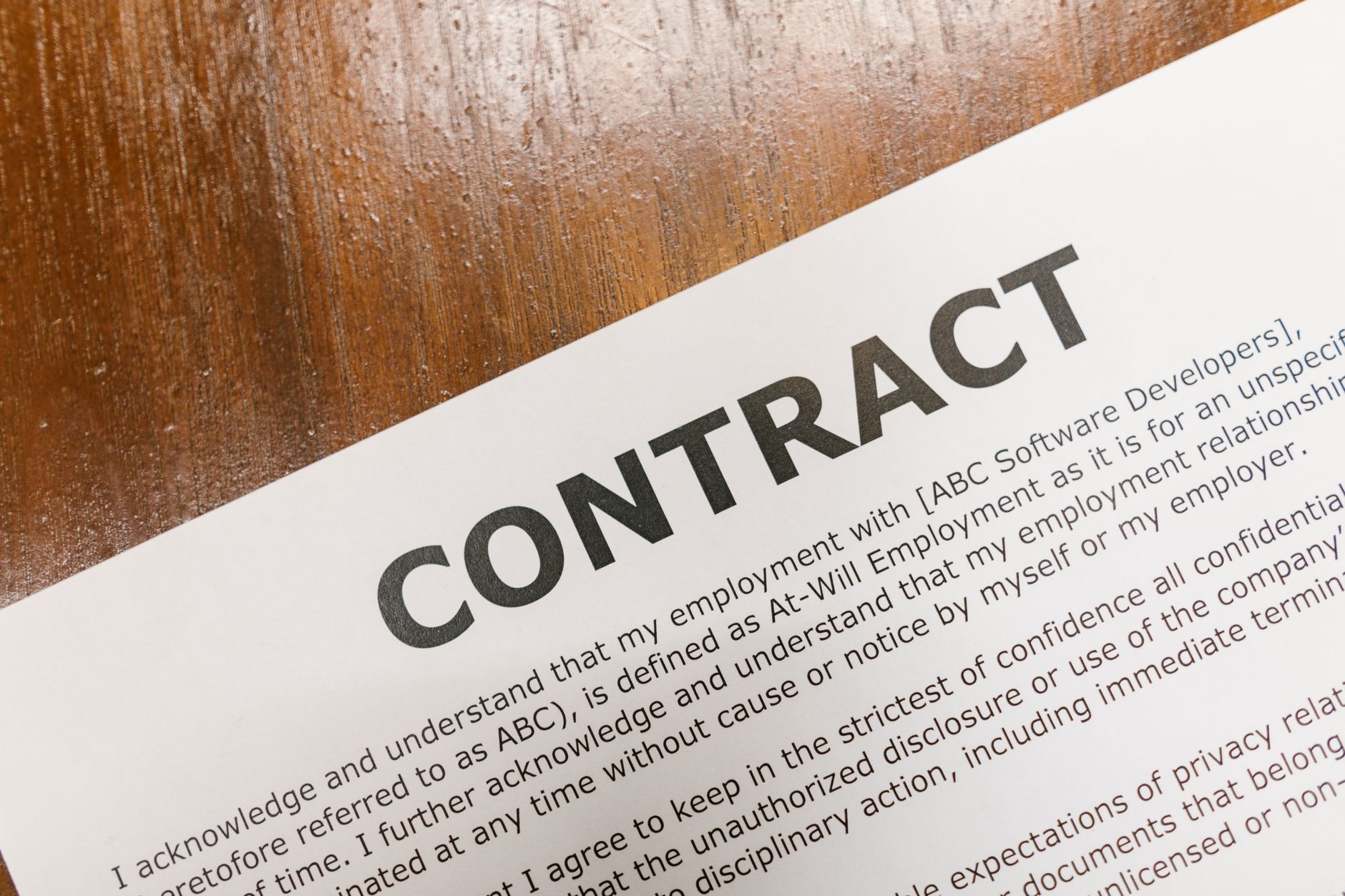 Legal professional examining contract terms and contractual commission survival clauses