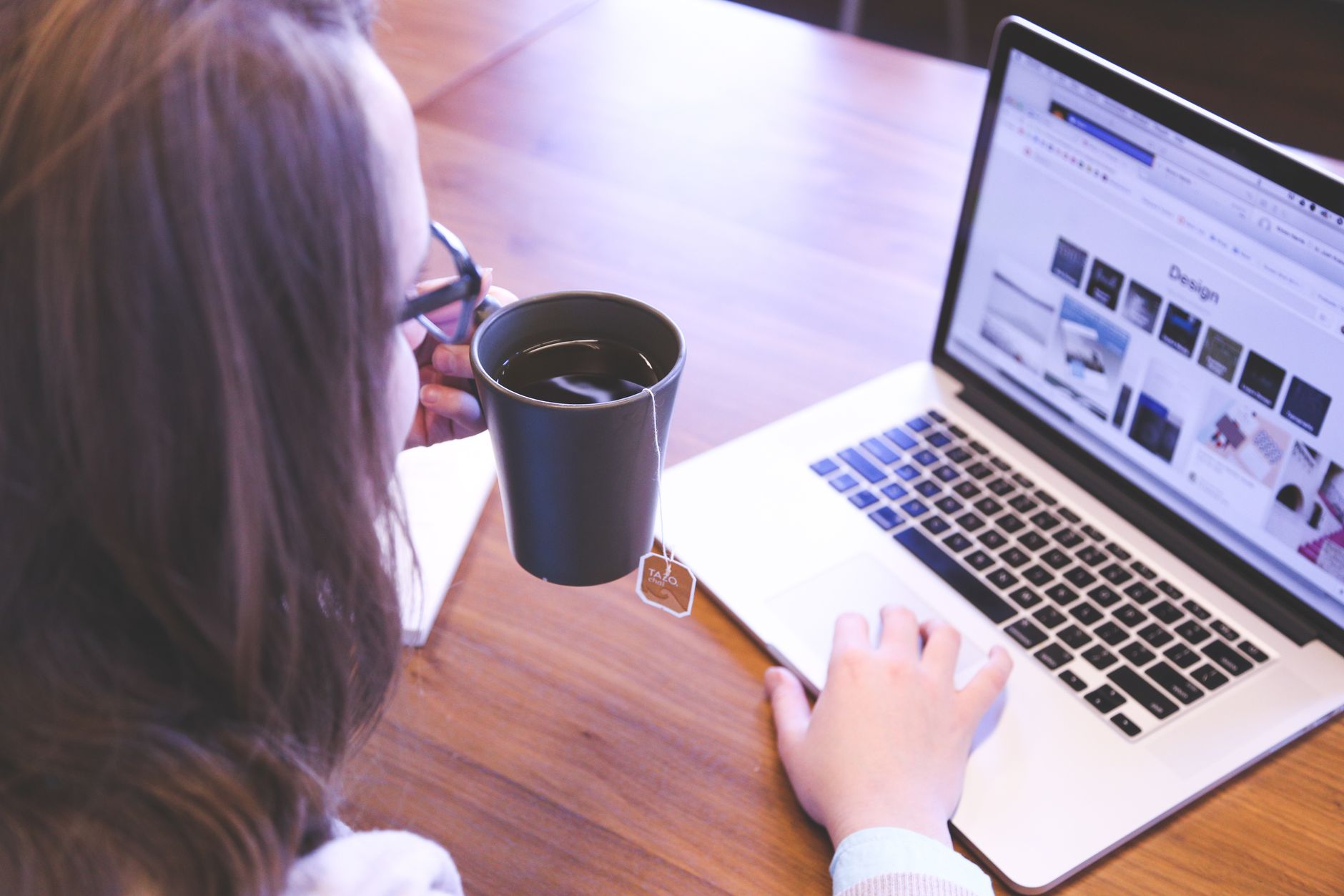 Professional travel consultant writing custom itinerary and social media copy on laptop